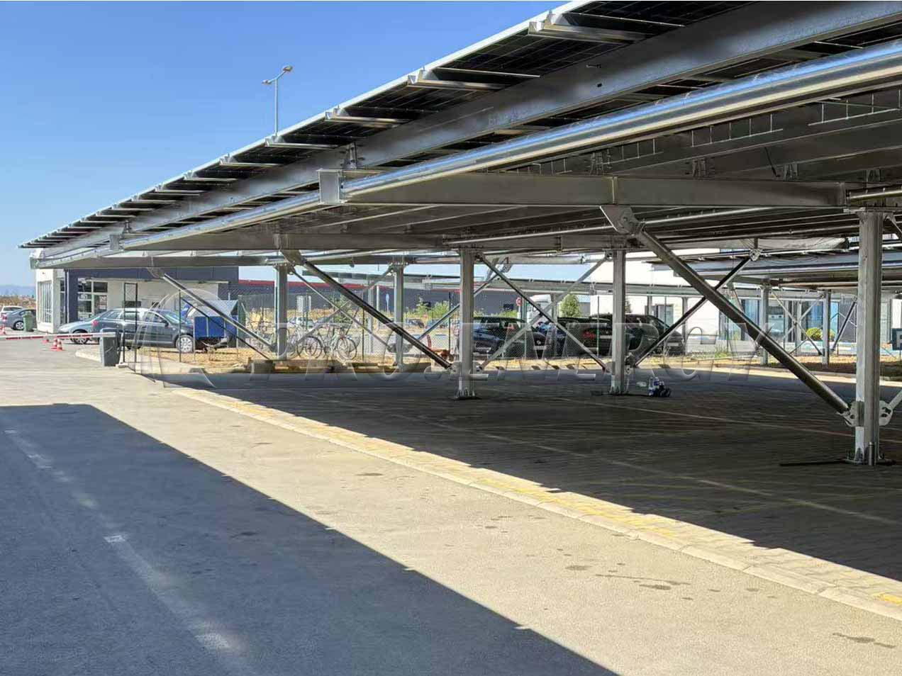 PROFENCE.ENERGY 11‑meter wide‑span carbon steel solar carport mounting system on project site, large parking solar canopy structure PROFENCE.ENERGY 11‑meter wide‑span carbon steel solar carport mounting system on project site, large parking solar canopy structure